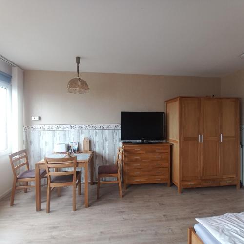 a living room with a dining table and a television at Ferienwohnung Conny am Südstrand Familie Bach in Burgtiefe auf Fehmarn 