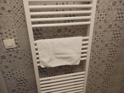 - une serviette suspendue à un porte-serviettes dans la salle de bains dans l'établissement Colmar City Center - Cosy Appartement BED' N' BREDALA Max, à Colmar