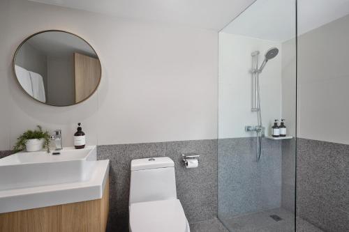 a bathroom with a toilet and a sink and a mirror at Somerset Sukhumvit 71 Bangkok in Bangkok
