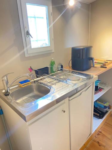 un comptoir de cuisine avec un évier et une fenêtre dans l'établissement Le Moulin de L'aire, à Lourmarin