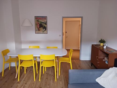 une salle à manger avec une table et des chaises jaunes dans l'établissement Colmar City Center - Cosy Appartement BED' N' BREDALA Max, à Colmar