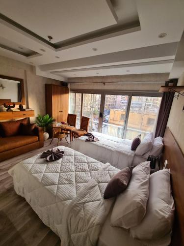a large bedroom with two beds and a large window at tourist hotel cairo downtown in Cairo