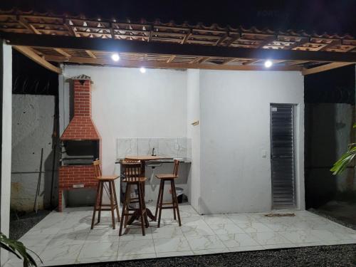 a patio with two chairs and a table and a stove at Casa de campoWebers-Nova Cruz PE in Igarassu