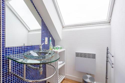 a bathroom with a glass sink and blue tiles at Maison familiale côté rivière in Audierne
