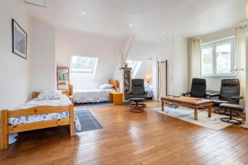 a bedroom with a bed and a table and chairs at Maison familiale côté rivière in Audierne