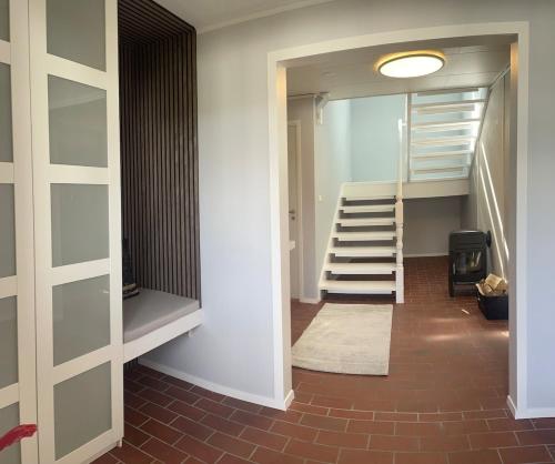 a hallway with a staircase and a stair case at Nice and comfortable apartment in Asker