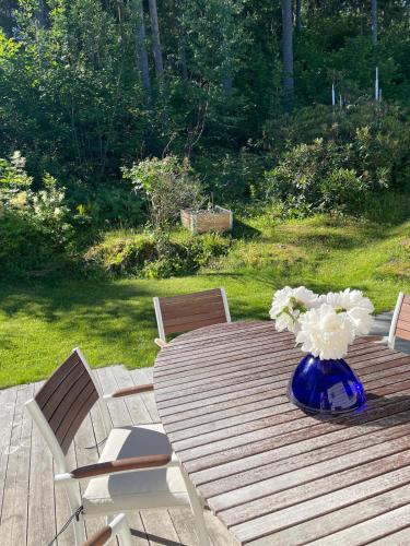 a wooden table with a blue vase with flowers on it at Nice and comfortable apartment in Asker