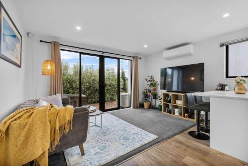 a living room with a couch and a table at Charming 2-Bedroom Townhouse in Christchurch