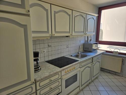 eine Küche mit weißen Schränken und einer Spüle in der Unterkunft Bremens Herz Weser und Stadion in Bremen