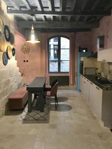 une cuisine avec une table, un banc et une table dans l'établissement Le 6 Bis by Les Cailloux Dorés, à Uzès