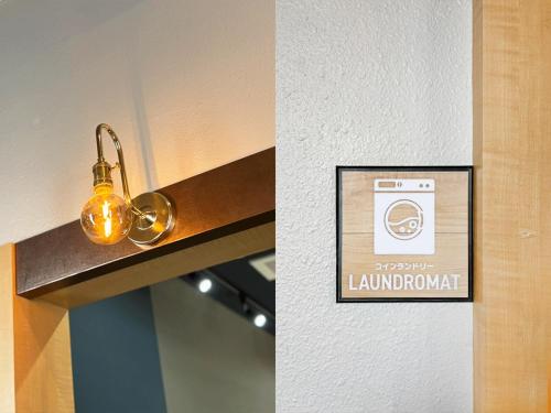a sign for a bathroom with a light on a wall at MolinHotels302アクティビティを満喫できる札幌定山渓 天然温泉付ホテル-1L1Room Q-Bed2&S-2 4persons in Jozankei