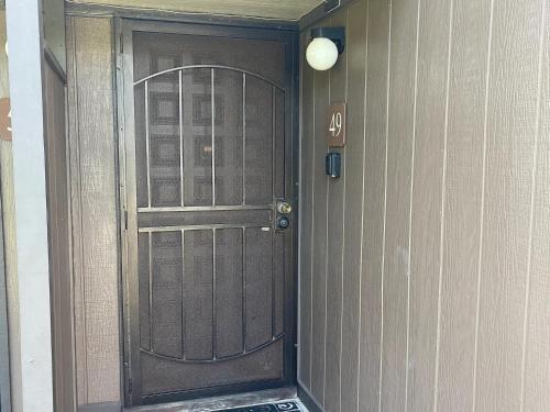 a wooden door with a sign on a wall at Ocean-View 1BR Condo on Black Sands Beach, Pool, Hot Tub in Pahala