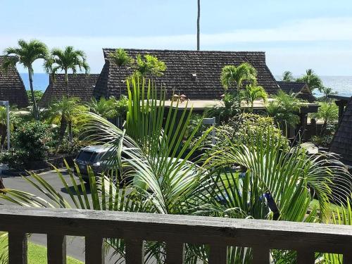 a view of a house with palm trees and the ocean at Ocean-View 1BR Condo on Black Sands Beach, Pool, Hot Tub in Pahala
