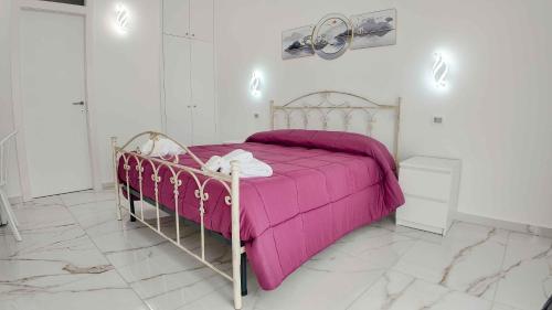 a bedroom with a bed with a pink blanket at Clarus Mons in Chiaromonte