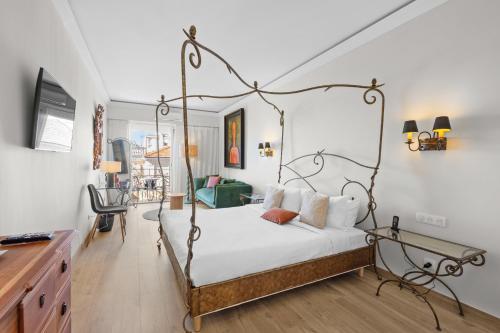 a bedroom with a bed with a metal frame at Hôtel La Villa Sainte Valérie Adults Only in Juan-les-Pins