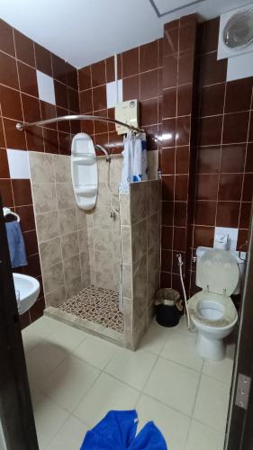 a bathroom with a shower with a toilet and a sink at Kata Lina guesthouse in Kata Beach