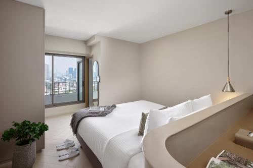 a bedroom with a bed and a large window at Somerset Sukhumvit 71 Bangkok in Bangkok