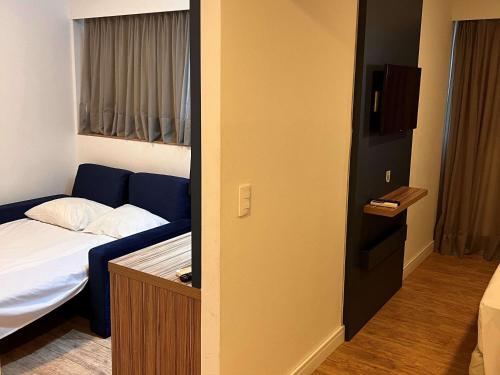 a hotel room with a bed and a small room with a door at ibis Styles Confins Aeroporto in Lagoa Santa