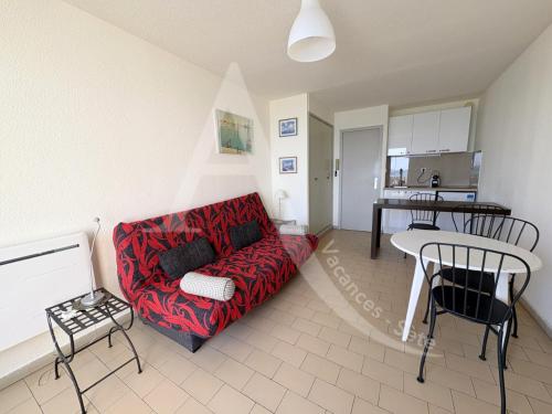 un salon avec un canapé rouge et une table dans l'établissement Residence front de mer studio cabine 4 personnes, à Sète