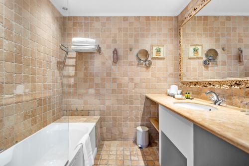 a bathroom with a tub and a sink at Hôtel La Villa Sainte Valérie Adults Only in Juan-les-Pins