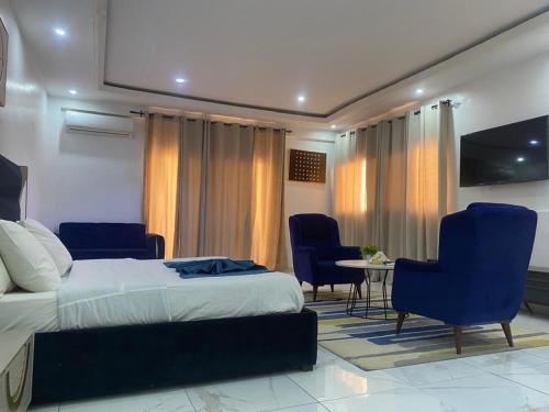 a bedroom with a bed and chairs and a table at Bi-Hotel 1 in Dakar