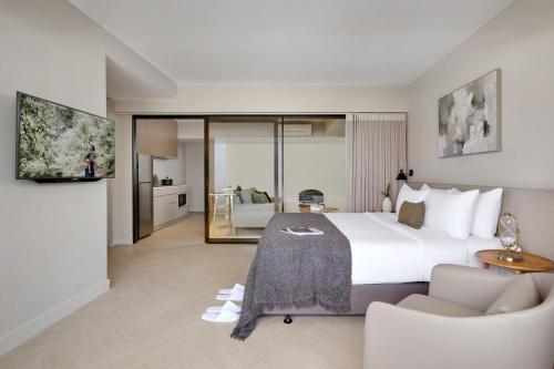 a bedroom with a large bed and a living room at Somerset Sukhumvit 71 Bangkok in Bangkok