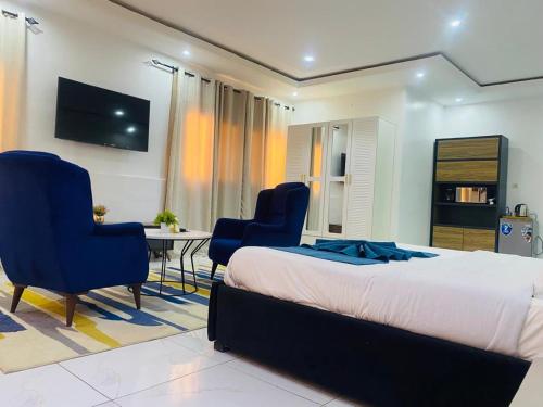 a bedroom with a bed and two chairs and a table at Bi-Hotel 1 in Dakar