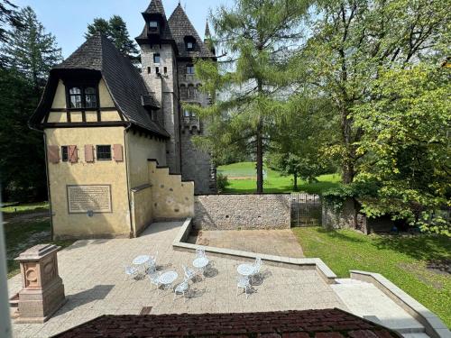 a group of chairs and a building with a castle at Gästehaus Schloss Leopoldstein in Eisenerz