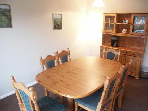 a dining room with a wooden table and chairs at Fell Croft in Pooley Bridge