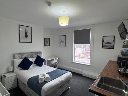 a bedroom with a bed and a sink in it at Newstead En-suite Studios in Nottingham