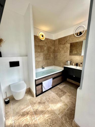 une salle de bain avec une baignoire, des toilettes et un lavabo dans l'établissement The62, à Carcassonne