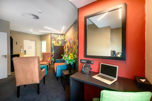 an office with a desk with a laptop and a mirror at Hotel Sky Sandton in Johannesburg