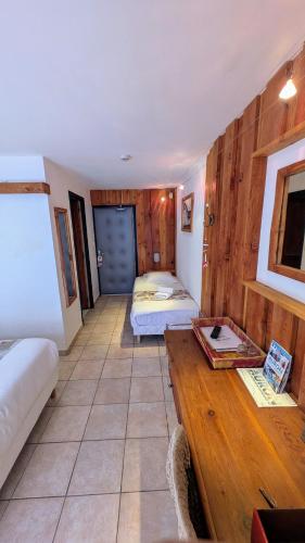 a room with two beds and a wooden table at Le Bataclan in Auron