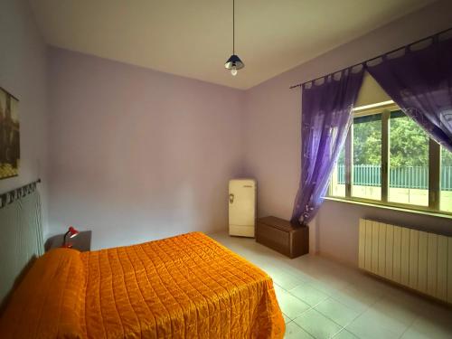 a bedroom with an orange bed and a window at Il Barbagianni in Chieuti