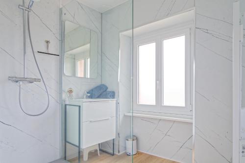 a white bathroom with a shower and a sink at Le Valnotte - Proche plage et traversées iles in Barneville-Carteret