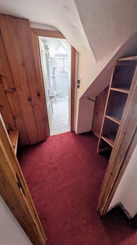 an attic hallway with a red carpet and wooden stairs at Le Bataclan in Auron