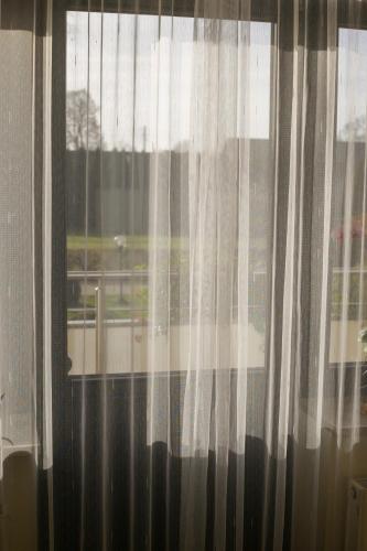 a window with white curtains in a room at Dom rekolekcyjny Vincentinum in Krzeszowice