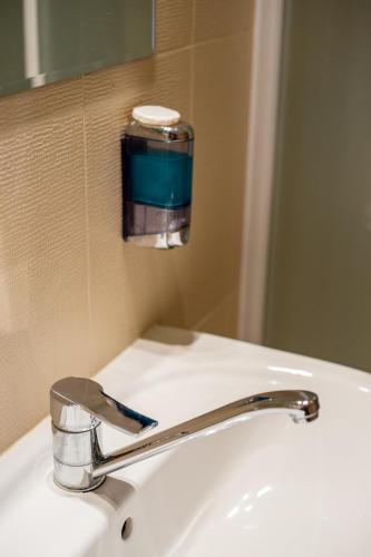 a bathroom sink with a faucet and a mirror at Dom rekolekcyjny Vincentinum in Krzeszowice