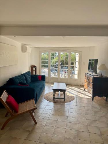 un salon avec un canapé bleu et une table dans l'établissement Appart 4/6 personnes, jardin, terrasse, vue mer, à La Londe-les-Maures