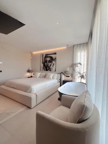 a white bedroom with two beds and a couch at Casa Troia in Alhaurín de la Torre