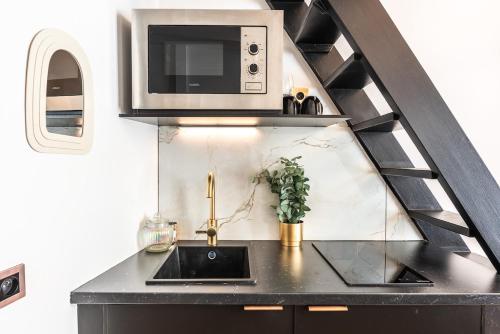 une cuisine avec un évier et un micro-ondes dans l'établissement Studio élégant esprit Loft avec AC, à Paris