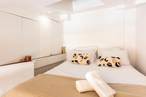 - une chambre blanche avec un lit et des oreillers en vache dans l'établissement Studio élégant esprit Loft avec AC, à Paris