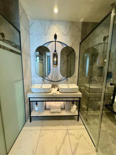 a bathroom with two sinks and a large mirror at Fifth Avenue Hotel in George Town