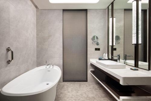 a bathroom with two sinks and a bath tub at Wyndham Shanwei Haifeng in Shanwei