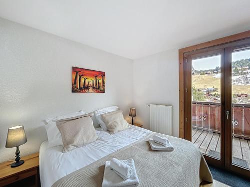 une chambre avec un lit et une grande fenêtre dans l'établissement Amarante-appartement-6 pers-proche piste, aux Gets