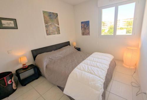 - une chambre avec un lit, 2 fenêtres et 2 lampes dans l'établissement Ref HORTENSE by Palmes d Or Properties, au Golfe-Juan
