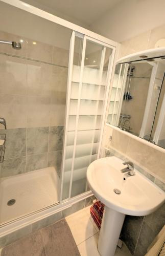 une salle de bain blanche avec un lavabo et une douche dans l'établissement Ref HORTENSE by Palmes d Or Properties, au Golfe-Juan