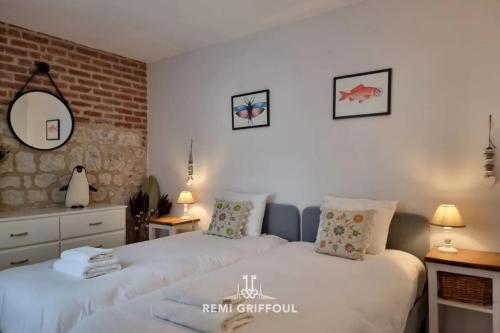 une chambre avec deux lits et un mur de briques dans l'établissement La Terrasse de Sacha House with Terrace & Fireplace 4 Guests, à Honfleur