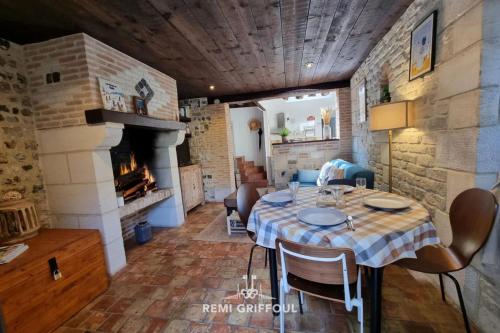une salle à manger avec une table et une cheminée dans l'établissement La Terrasse de Sacha House with Terrace & Fireplace 4 Guests, à Honfleur