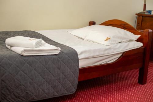 a bed with two white towels on top of it at Dom rekolekcyjny Vincentinum in Krzeszowice